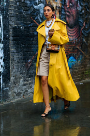 yellow trench coat, oversize trench coat, white top, big chain necklace, golden necklace, plastic earrings, flowers earrings, burberry bag, crossbody bag, checked bag, brown leather bag, big buckle bag, beige bermuda shorts, high heels sandals, high heels slippers, animal print sandals, beige leather bag, silk scarf, printed scarf, fashion week, frenchystyle, FW, jonathan paciullo, street style, vertical, full length
