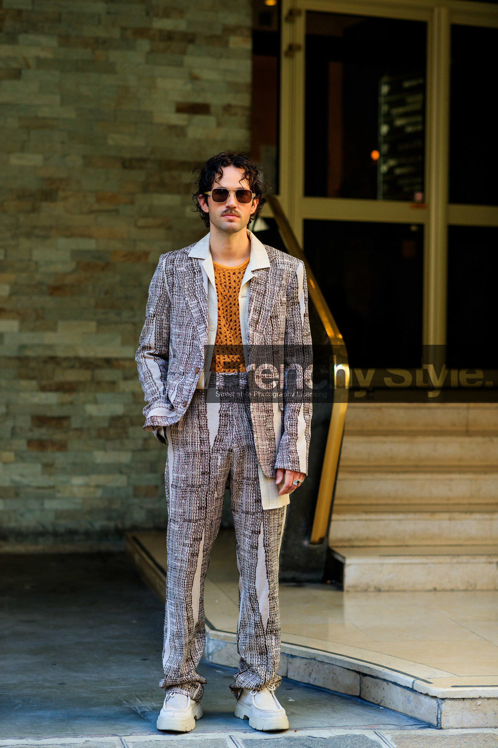 acne studios jacket, acne studios look, orange top, fishnet top, monogrammed jacket, monogrammed pants, monogrammed look, beige jacket, beige pants, beige suits, printed jacket, printed pants, logo all over, logo printed jacket, logo printed pants, aviator sunglasses, sheer sunglasses, beige shoes, beige suede shoes, big sole derbies, big sole shoes, beige derbies, beige suede derbies, JS roques, fashion week, frenchystyle, FW, jonathan paciullo, street style, PFW, PARIS, SPRING SUMMER 2022, SS 22, vertical, full length