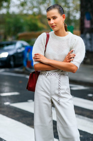 model, white total look, white pullover, white pants, knitwear, short sleeves pullover, balloon sleeves, leather pants, flare pants, chain belt, silvered belt, red leather bag, shoulder bag, black leather boots, laced boots, big sole boots, fashion week, frenchystyle, FW, jonathan paciullo, street style, vertical, detail, atmosphere details