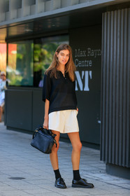 black polo shirt, oversize polo shirt, school girl look, light beige shorts, loose shorts, black leather bag, hand bag, doc marteens shoes, black leather shoes, black socks, laced shoes, high waist shorts, fashion week, frenchystyle, FW, jonathan paciullo, street style, vertical, full length