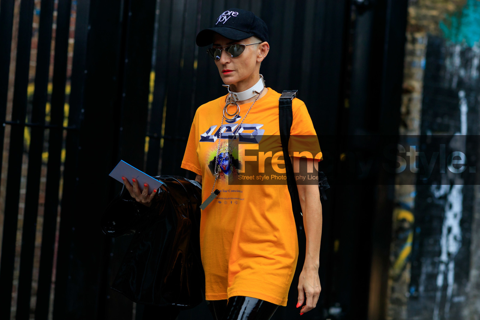 prada sunglasses, futurist shape sunglasses, metalic frame sunglasses, black cap, big chocker, leather chocker, studs chocker, orange t-shirt, short sleeves t-shirt, printed t-shirt, black vinyl pants, black vinyl boots, christopher kane cap, fashion week, frenchystyle, FW, jonathan paciullo, street style, atmosphere details, horizontal, detail