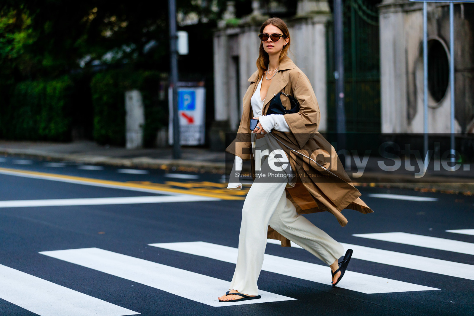 beige trench coat, camel trenchcoat, white top, white pants, knit pants, knitwear, laced top, asymmetrical top, cropped top, scale sunglasses, bottega veneta sunglasses, black sandals, flat sandals, flip flop shoes, silvered necklace, multi necklace, jacqueline zelwis, street style, jonathan paciullo, FW, frenchystyle, fashion week, MFW, MILAN, SPRING SUMMER 2021, SS 21, horizontal, atmosphere details, full length