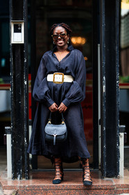 black dress, long sleeves dress, scale sunglasses, bottega veneta sunglasses, butterfly sunglasses, golden earrings, diamond earrings, round shape earrings, dress shirt, button dress, belted dress, white leather belt, golden buckle belt, black shoes, suede shoes, laced shoes, black leather bag, hand bag, lois opoku, street style, jonathan paciullo, FW, frenchystyle, fashion week, MFW, MILAN, SPRING SUMMER 2021, SS 21, vertical, full length
