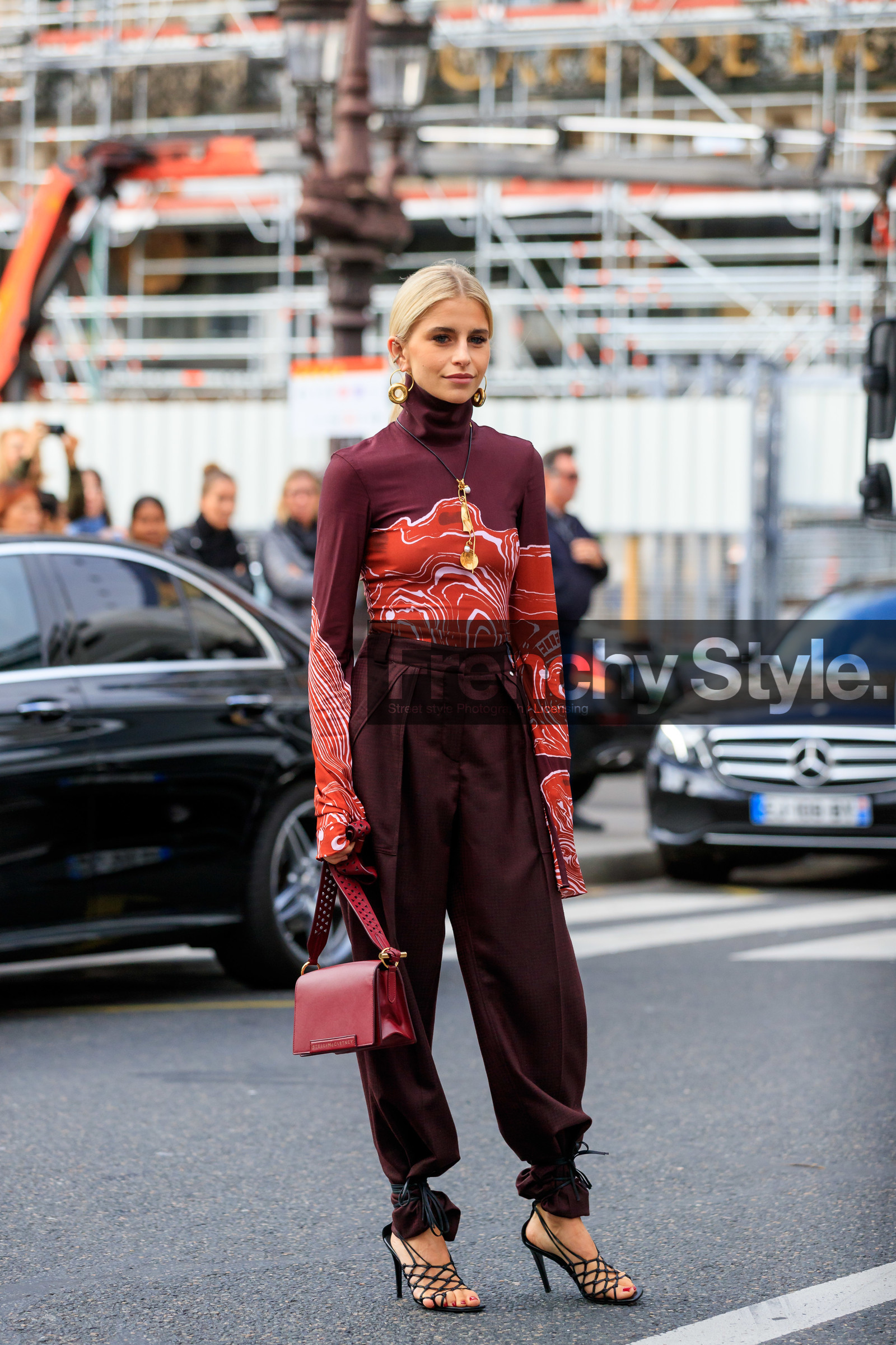 caro daur, stella mccartney bag, stella mccartney look, stella mccartney look, stella mccartney top, stella mccartney pants, burgundy pants, burgundy leather bag, burgundy top, red top, tight top, high collar top, turtleneck top, tailored pants, loose pants, golden earrings, golden necklace, long necklace, dangling earrings, hoop earrings, round earrings, round shape earrings, diamond earrings, big earrings, big necklace, charms necklace, black leather sandals, multi straps sandals, high heels sandals, long sleeves top, printed top, PARIS, PFW, SPRING SUMMER 2020, SS 20, fashion week, frenchystyle, FW, jonathan paciullo, street style, vertical, full length