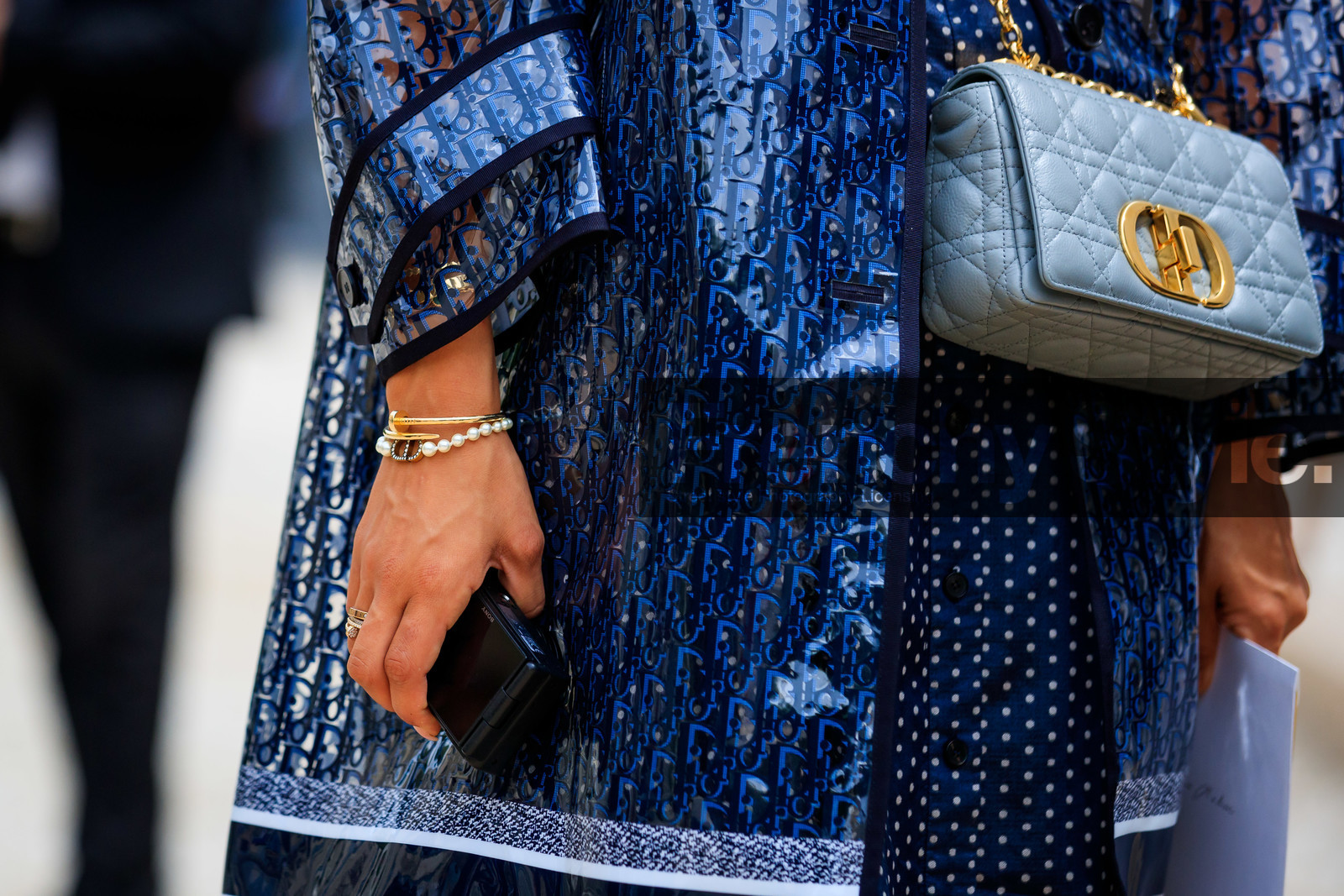 dior bag, logo all over, dior bracelet, cartier bracelet, cartier clou bracelet, cartier ring, golden bracelet, golden ring, pearl bracelet, initials bracelet, close up detail, jewel close up, bag detail, light blue bag, light blue leather bag, quilted bag, blue bag, blue leather bag, chain strap bag, caro dior bag, sheer trench coat, monogrammed trench coat, monogrammed parka, monogrammed coat, tamara kalinic, fashion week, frenchystyle, FW, jonathan paciullo, street style, PFW, PARIS, AUTUMN WINTER 2021-2022, FALL WINTER 2021-2022, FW 21-22, atmosphere details, horizontal, detail
