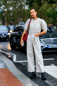 model, white total look, white pullover, white pants, knitwear, short sleeves pullover, balloon sleeves, leather pants, flare pants, chain belt, silvered belt, red leather bag, shoulder bag, black leather boots, laced boots, big sole boots, fashion week, frenchystyle, FW, jonathan paciullo, street style, vertical, full length