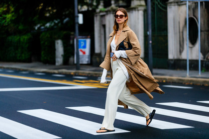 beige trench coat, camel trenchcoat, white top, white pants, knit pants, knitwear, laced top, asymmetrical top, cropped top, scale sunglasses, bottega veneta sunglasses, black sandals, flat sandals, flip flop shoes, silvered necklace, multi necklace, jacqueline zelwis, street style, jonathan paciullo, FW, frenchystyle, fashion week, MFW, MILAN, SPRING SUMMER 2021, SS 21, horizontal, atmosphere details, full length
