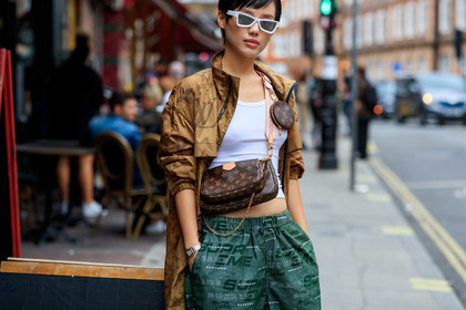 white sunglasses, futurist shape sunglasses, louis vuitton bag, monogrammed bag, crossbody bag, logo strap bag, louis vuitton jacket, beige waterproof jacket, beige parka, green pants, jogging pants, supreme pants, street wear look, monogrammed jacket, logo all over, cartier watch, panthere cartier watch, silver and golden watch, fashion week, frenchystyle, FW, jonathan paciullo, street style, atmosphere details, horizontal, detail