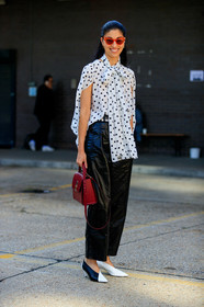 caroline issa, polka dots shirt, white shirt, black dots, lavalliere collar, sleeveless shirt, black leather pants, cropped pants, black and white look, red sunglasses, black and white shoes, kitten heels shoes, black vinyl pants, oversize pants, burgundy leather bag, hand bag, fashion week, frenchystyle, FW, jonathan paciullo, street style, vertical, full length