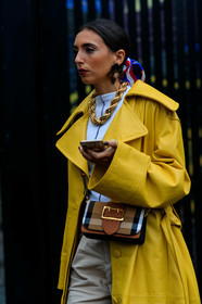 yellow trench coat, oversize trench coat, white top, big chain necklace, golden necklace, plastic earrings, flowers earrings, burberry bag, crossbody bag, checked bag, brown leather bag, big buckle bag, beige bermuda shorts, fashion week, frenchystyle, FW, jonathan paciullo, street style, vertical, detail, atmosphere details