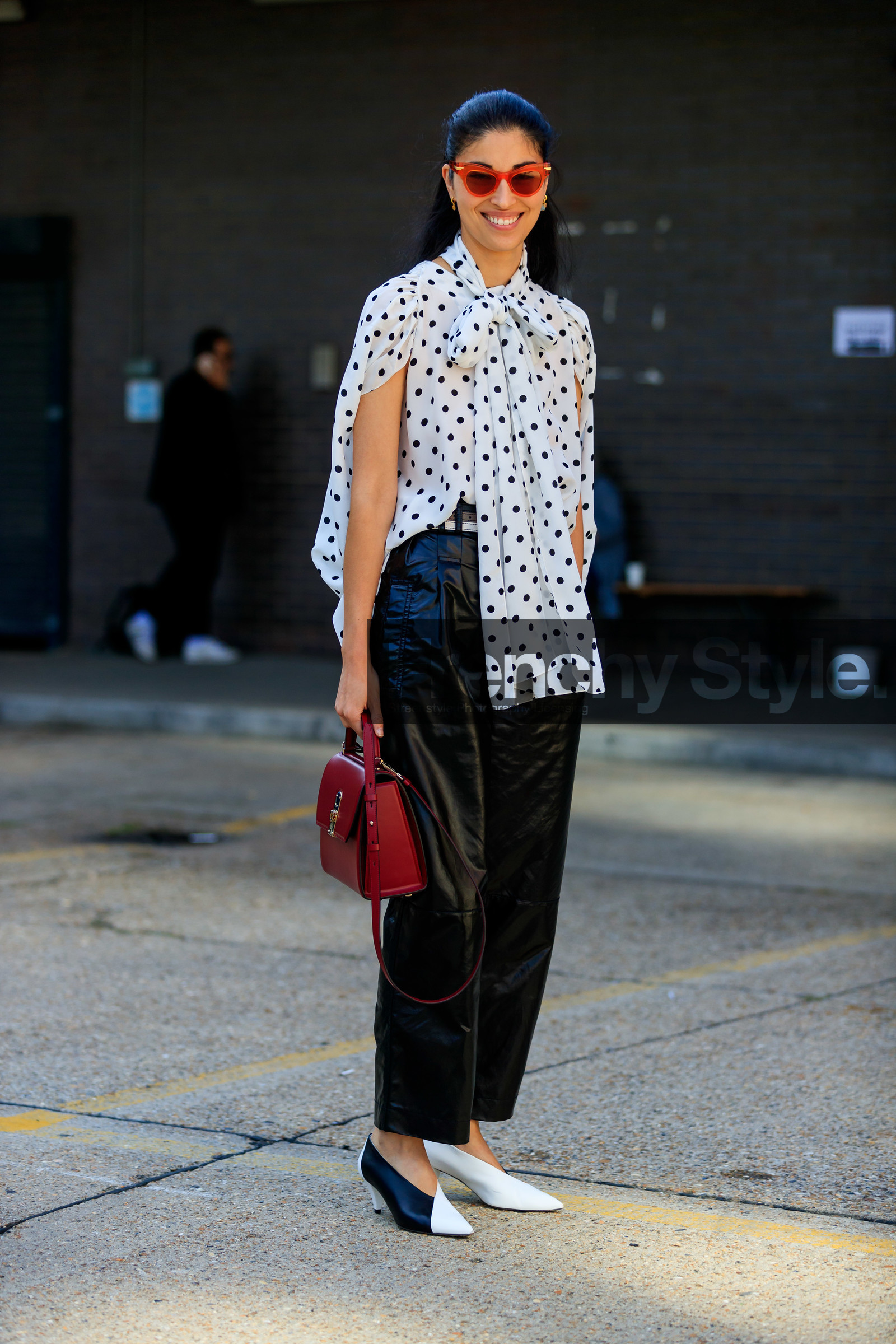 caroline issa, polka dots shirt, white shirt, black dots, lavalliere collar, sleeveless shirt, black leather pants, cropped pants, black and white look, red sunglasses, black and white shoes, kitten heels shoes, black vinyl pants, oversize pants, burgundy leather bag, hand bag, fashion week, frenchystyle, FW, jonathan paciullo, street style, vertical, full length