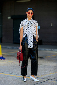 caroline issa, polka dots shirt, white shirt, black dots, lavalliere collar, sleeveless shirt, black leather pants, cropped pants, black and white look, red sunglasses, black and white shoes, kitten heels shoes, black vinyl pants, oversize pants, burgundy leather bag, hand bag, fashion week, frenchystyle, FW, jonathan paciullo, street style, vertical, full length