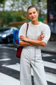 model, white total look, white pullover, white pants, knitwear, short sleeves pullover, balloon sleeves, leather pants, flare pants, chain belt, silvered belt, red leather bag, shoulder bag, black leather boots, laced boots, big sole boots, fashion week, frenchystyle, FW, jonathan paciullo, street style, vertical, detail, atmosphere details