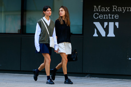 school girl look, black polo shirt, oversize polo shirt, light beige shorts, loose shorts, black leather bag, hand bag, doc marteens shoes, black leather shoes, black socks, laced shoes, high waist shorts, white shirt, oversize shirt, knitwear, sleeveless pullover, kaki pullover, man style pullover, porter bag, crossbody bag, black and white bag, square shape bag, navy blue skirt, pleated skirt, long sleeves shirt, oversize sleeves, fashion week, frenchystyle, FW, jonathan paciullo, street style, atmosphere details, horizontal, full length