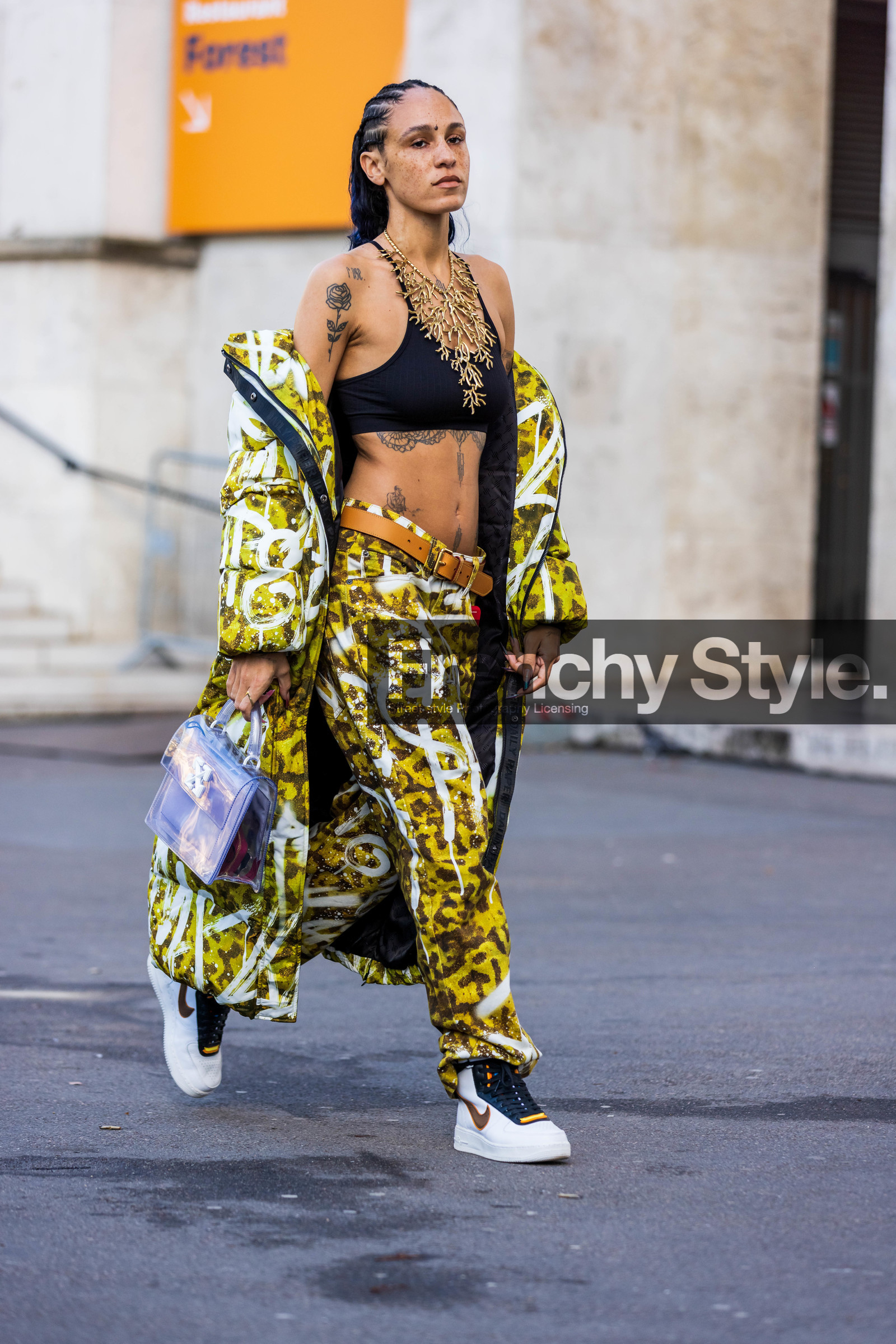 bag, belt, black bra, bra, camel belt, coat, freckles, gold necklace, Hera Pradel, leather belt, long coat, long puffer, necklace, nike sneakers, print, printed coat, printed pants, printed puffer, puffer, sneakers, statement necklace, tattoo, transparent bag, white sneakers, yellow coat, yellow pants, fashion week, frenchystyle, FW, jonathan paciullo, street style, PFW, PARIS, SPRING SUMMER 2022, SS 22, vertical, full length
