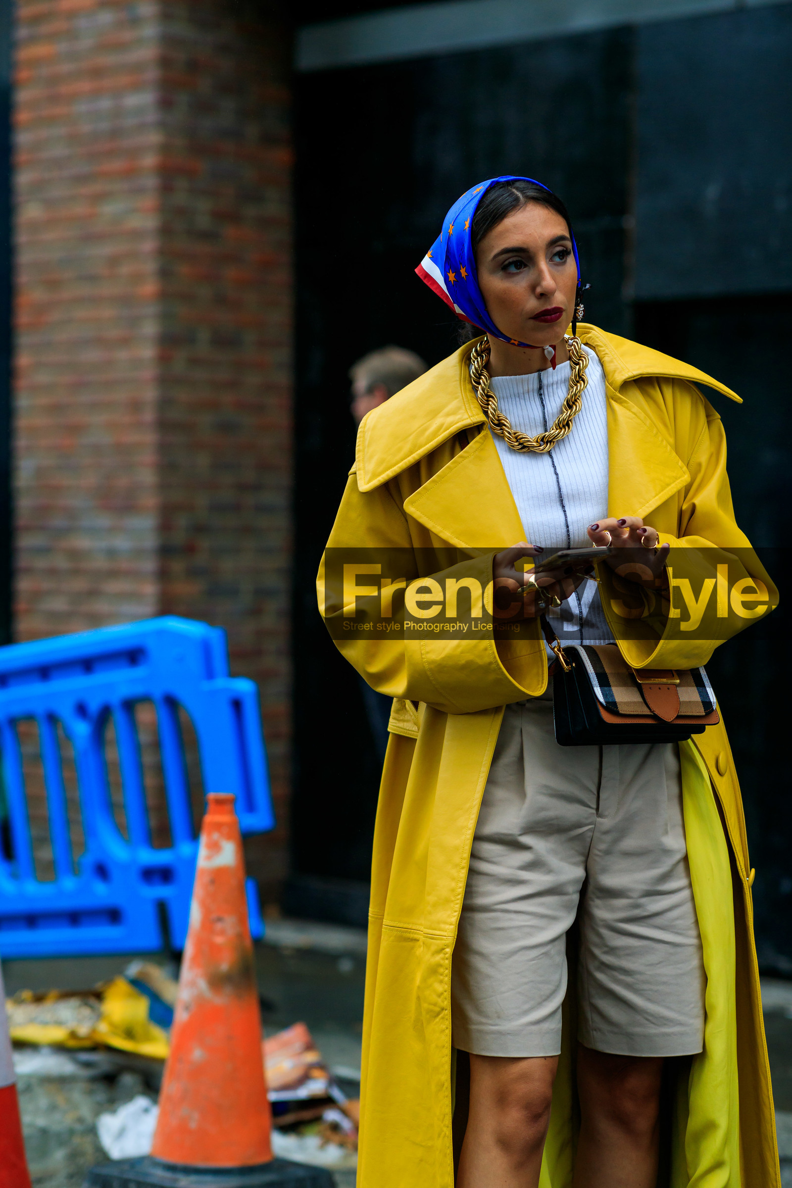 animal print sandals, beige bermuda shorts, big buckle bag, big chain necklace, brown leather bag, burberry bag, beige leather bag, checked bag, crossbody bag, flowers earrings, golden necklace, high heels sandals, high heels slippers, oversize trench coat, plastic earrings, white top, yellow trench coat, fashion week, frenchystyle, FW, jonathan paciullo, street style, vertical, detail, atmosphere details