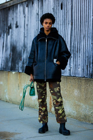 black coat, leather coat, afro hair, military pants, printed pants, mini bag, mini telfar bag, telfar bag, telfar crossbody, telfar handbag, green handbag, silver creole, silver earrings, bottega veneta boots, black boots, street style, jonathan paciullo, FW, frenchystyle, fashion week, NYFW, NEW YORK, AUTUMN WINTER 2022-2023, FALL WINTER 2022_2023, FW 22-23, vertical, full length
