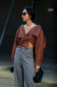 beatrice gutu, brown leather top, cropped top, asymmetrical top, long sleeves top, grey pants, white leather shoes, sharp end shoes, khaite bag, black leather clutch, multi necklace, pearl necklace, black sunglasses, fashion week, frenchystyle, FW, jonathan paciullo, street style, vertical, detail, atmosphere details