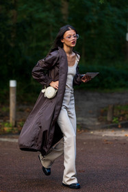 bag, beige bag, beige pants, beige top, black boots, brown raincoat, courreges bag, flare pants, glasses, Jade Rabarivelo, long raincoat, pants, raincoat, ribbed top, round bag, transparent glasses, street style, jonathan paciullo, FW, frenchystyle, fashion week, PFW, PARIS, SPRING SUMMER 2022, SS 22, vertical, full length