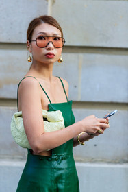 green leather dress, green dress, sleeveless dress, yellow leather bag, light yellow leather bag, plaited bag, round shape bag, bottega veneta bag, golden earrings, dangling earrings, orange sunglasses, aviator sunglasses, close up detail, fashion week, frenchystyle, FW, jonathan paciullo, street style, PFW, PARIS, AUTUMN WINTER 2021-2022, FALL WINTER 2021-2022, FW 21-22, vertical, atmosphere details, detail