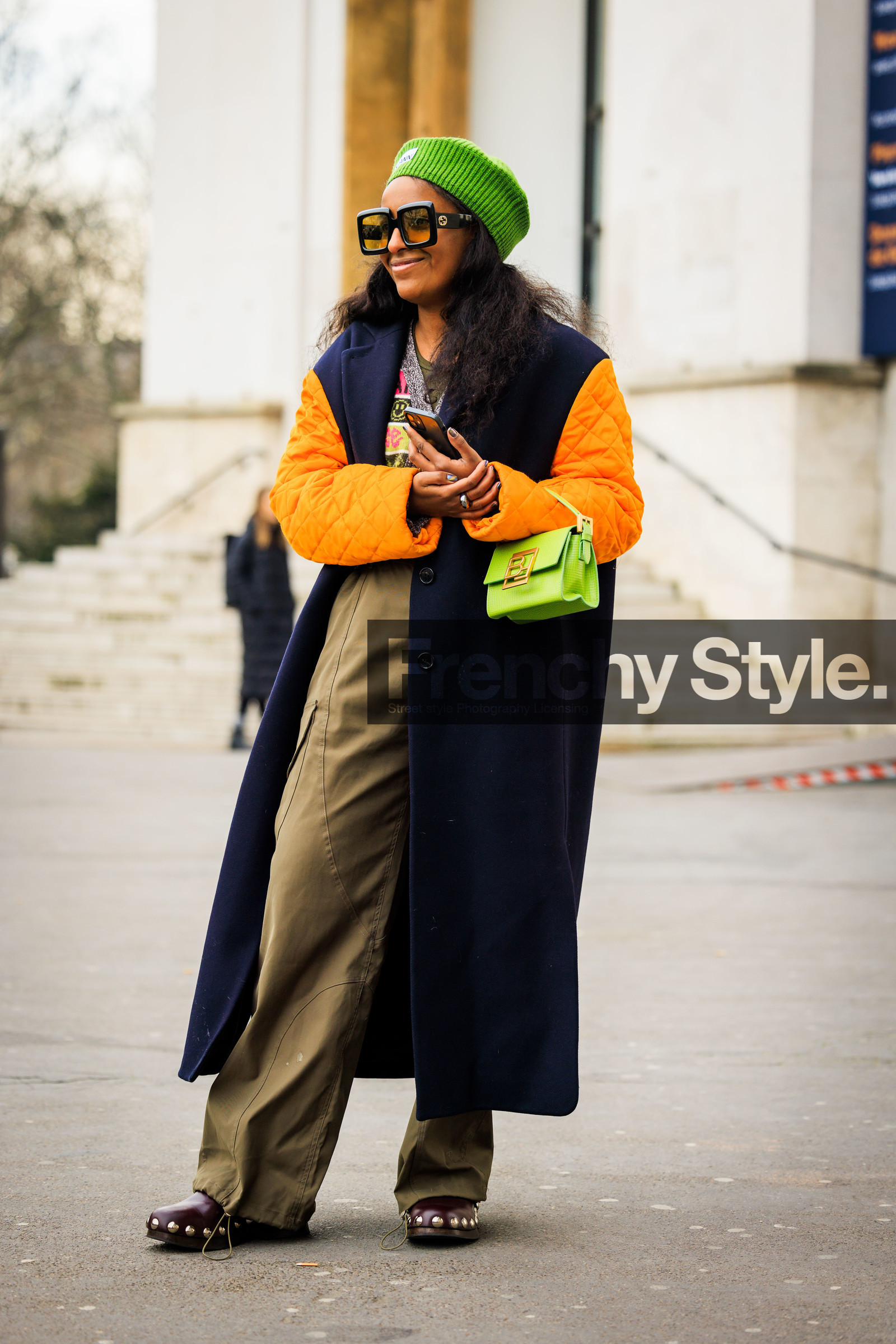 ganni beanie, green beanie, orange sleeves, black winter coat, kaki pants, baggy trousers, studded clogs, green handbag, black sunglasses, ganni cardigan, fashion week, frenchystyle, FW, jonathan paciullo, street style, AUTUMN WINTER 2022-2023, FALL WINTER 2022_2023, FW 22-23, PFW, PARIS, vertical, full length, dual toned jakcet