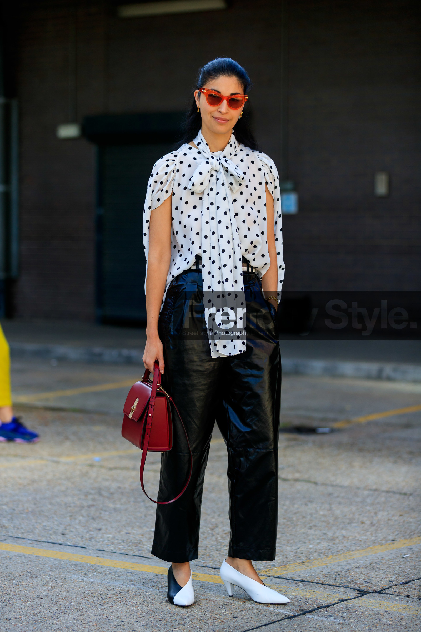 caroline issa, polka dots shirt, white shirt, black dots, lavalliere collar, sleeveless shirt, black leather pants, cropped pants, black and white look, red sunglasses, black and white shoes, kitten heels shoes, black vinyl pants, oversize pants, burgundy leather bag, hand bag, fashion week, frenchystyle, FW, jonathan paciullo, street style, vertical, full length