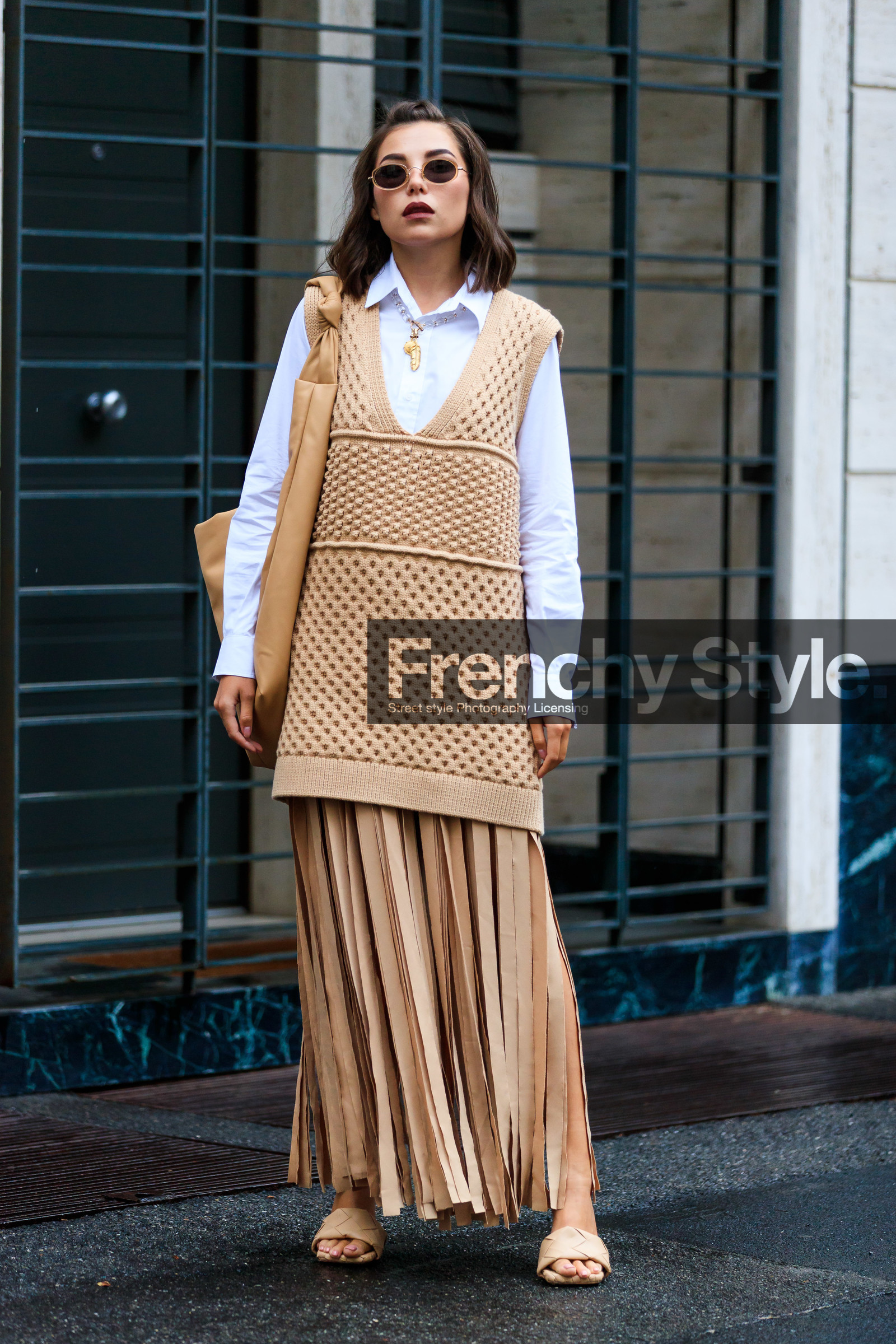 white shirt, sleeveless pullover, beige pullover, beige skirt, beige leather sandals, beige leather slippers, beige leather bag, round shape glasses, metalic frame sunglasses, long pullover, long skirt, split skirt, pullover dress, openwork pullover, pleated skirt, plaited sandals, plaited slippers, high heels sandals, high heels slippers, big bag, shoulder bag, karina nigay, street style, jonathan paciullo, FW, frenchystyle, fashion week, MFW, MILAN, SPRING SUMMER 2021, SS 21, vertical, full length