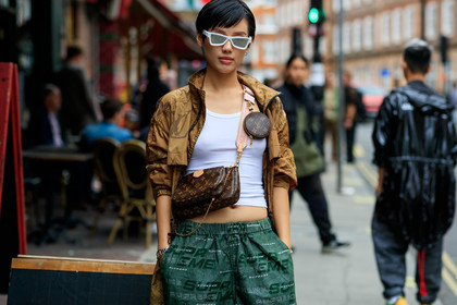 white sunglasses, futurist shape sunglasses, louis vuitton bag, monogrammed bag, crossbody bag, logo strap bag, louis vuitton jacket, beige waterproof jacket, beige parka, green pants, jogging pants, supreme pants, street wear look, monogrammed jacket, logo all over, cartier watch, panthere cartier watch, silver and golden watch, fashion week, frenchystyle, FW, jonathan paciullo, street style, atmosphere details, horizontal, detail