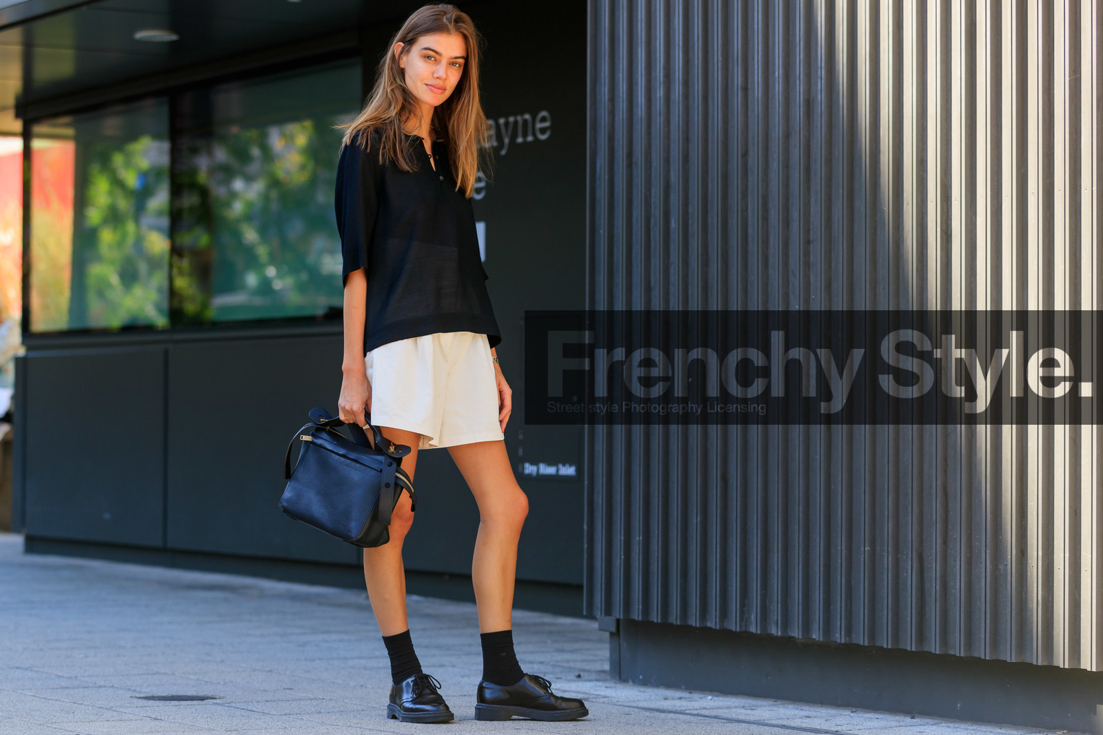 black polo shirt, oversize polo shirt, school girl look, light beige shorts, loose shorts, black leather bag, hand bag, doc marteens shoes, black leather shoes, black socks, laced shoes, high waist shorts, fashion week, frenchystyle, FW, jonathan paciullo, street style, atmosphere details, horizontal, full length