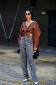 beatrice gutu, brown leather top, cropped top, asymmetrical top, long sleeves top, grey pants, white leather shoes, sharp end shoes, khaite bag, black leather clutch, multi necklace, pearl necklace, black sunglasses, fashion week, frenchystyle, FW, jonathan paciullo, street style, vertical, full length