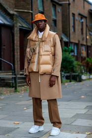 jean jacques ndjoli, beige total look, beige pants, beige look, beige coat, orange hat, pleated hat, metalic frame sunglasses, sleeveless coat, down jacket, sleeveless down jacket, burberry bag, crossbody bag, monogrammed bag, white sneakers, fashion week, frenchystyle, FW, jonathan paciullo, street style, vertical, full length