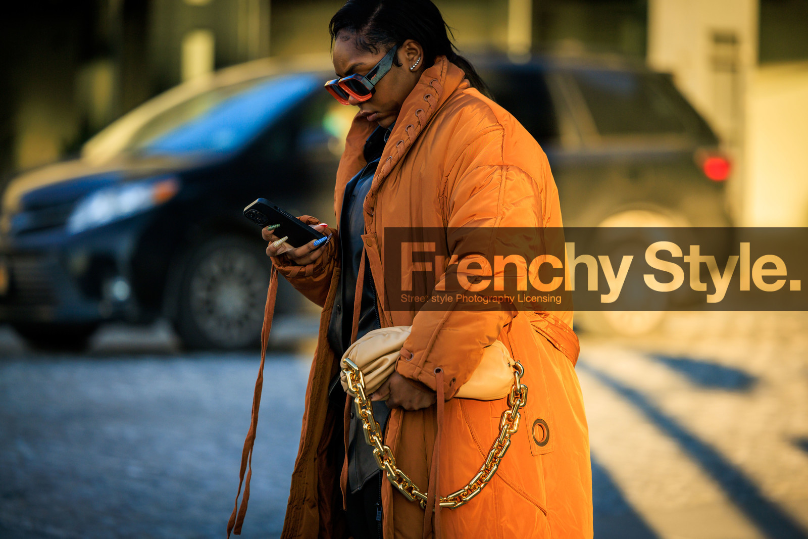 oversized winter coat, orange coat, puffed coat, chained bag, bottega veneta bag, beige handbag, iphone, black and orange sunglasses, black sunglasses, silver earrings, blue nails, close up, street style, jonathan paciullo, FW, frenchystyle, fashion week, NYFW, NEW YORK, AUTUMN WINTER 2022-2023, FALL WINTER 2022_2023, FW 22-23, atmosphere details, horizontal